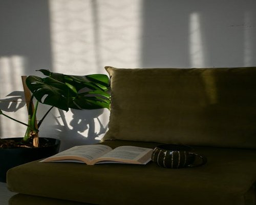 A cozy corner in an apartment with a book and a cup of coffee under natural sunlight